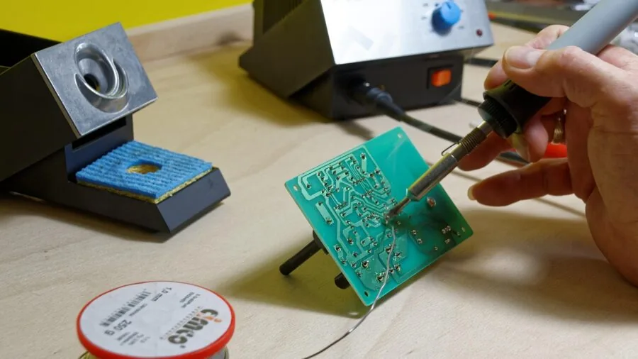Skilled technician using multimeter to measure electrical circuit in professional workshop setting
