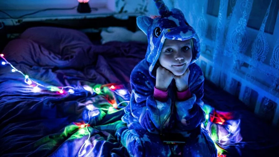 Sleep-deprived parent searching for pacifier in dark bedroom at night