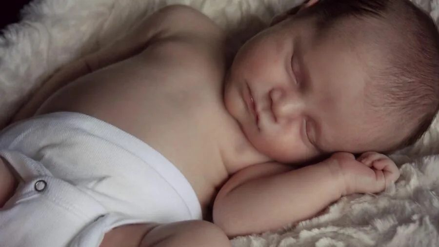 Sleeping infant in calm nursery environment during daytime nap with soft natural lighting