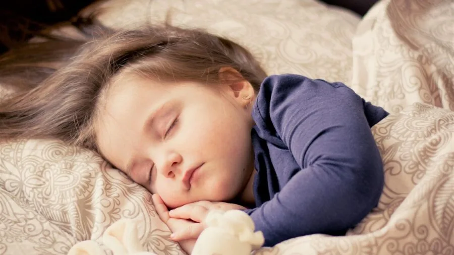 Sleeping infant in properly fitted wearable blanket showing correct sizing and safe positioning