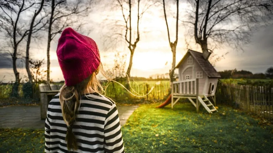 Small child enjoying outdoor playtime in a safe garden setting with toys