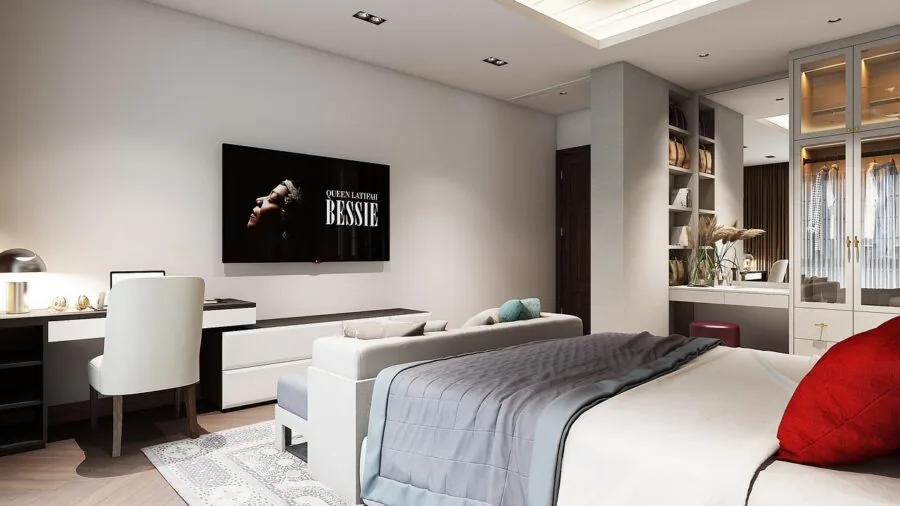 Small TV mounted on bedroom wall above dresser in modern apartment bedroom setting