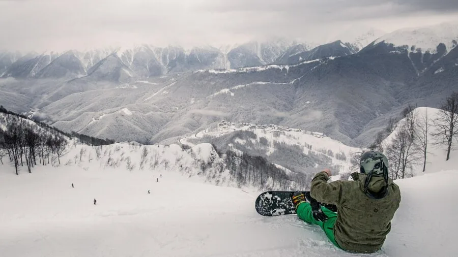 Snowboarder carefully fitting and adjusting boot fit before hitting the slopes