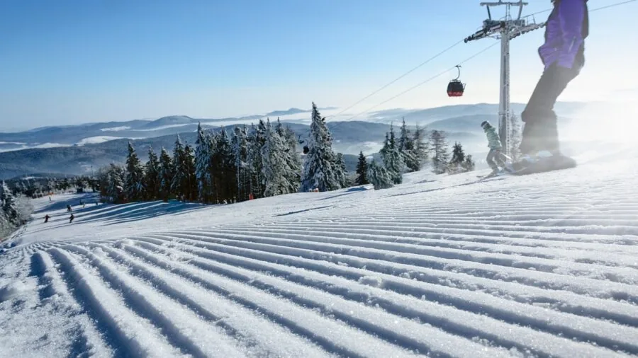 Snowboarder in action on snowy mountain terrain demonstrating riding technique and style