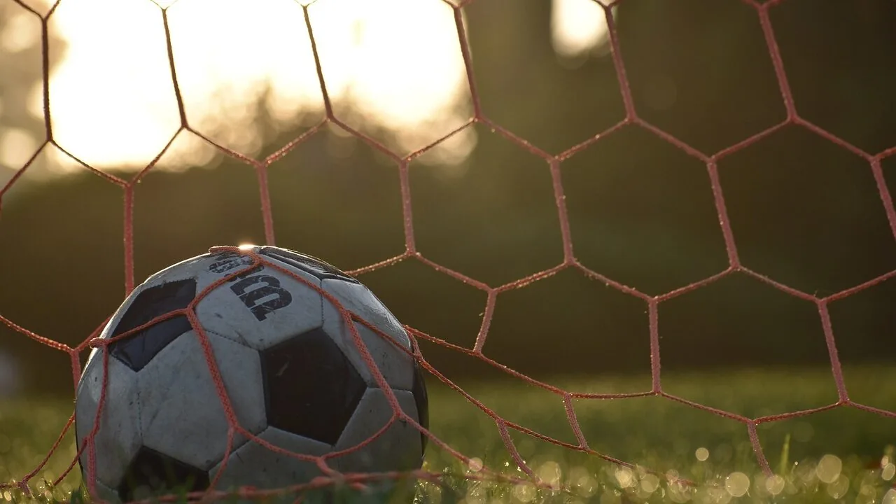 Soccer goal with net on grass field during daytime