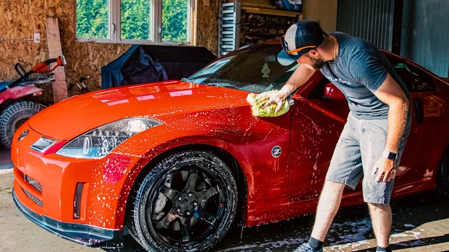 Someone carefully applying wax to a car's surface in natural daylight