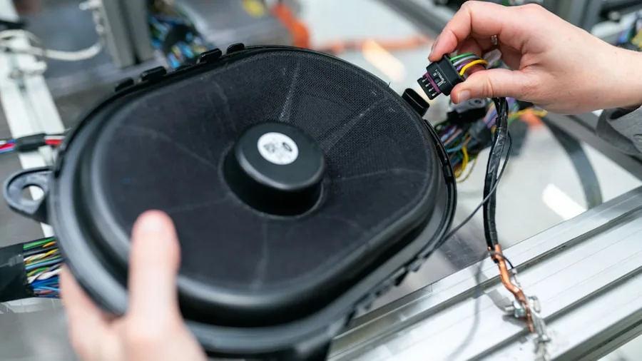 Someone carefully connecting audio cables to speaker equipment during home setup installation