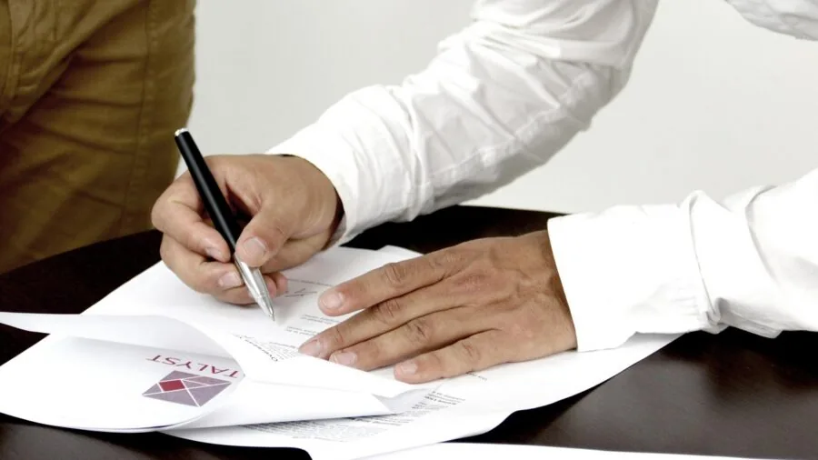 Someone carefully reading technical specifications on paper while taking notes, representing detailed product research and comparison