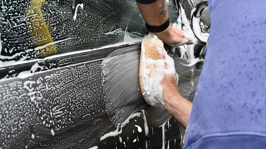 Someone carefully waxing a car's surface with protective product application technique
