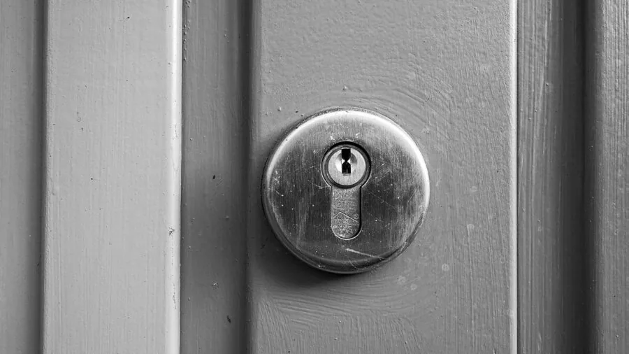 Someone inspecting a residential door lock mechanism up close in natural lighting