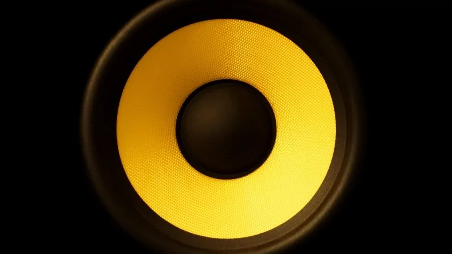 Someone installing and calibrating speakers in a living room for a home theater system setup