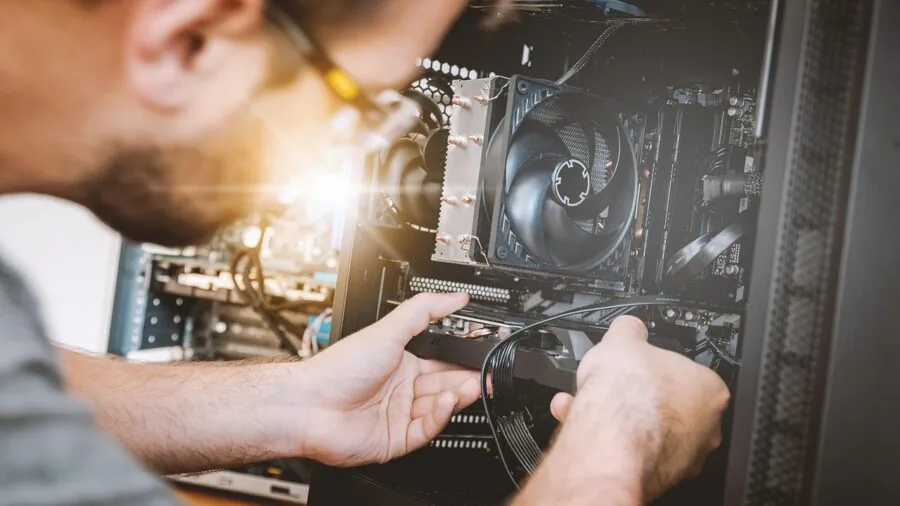 Someone installing RAM into desktop computer motherboard during DIY PC build assembly