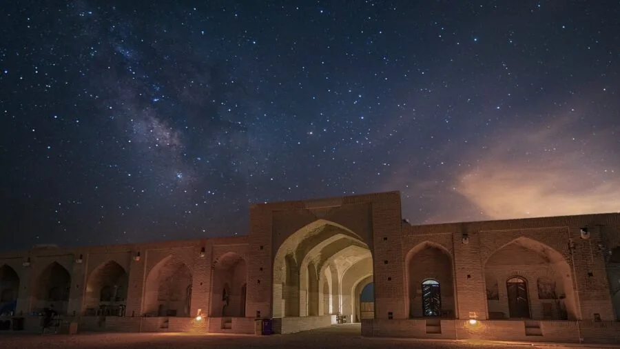Someone looking through a telescope under starry night sky, exploring astronomy outdoors