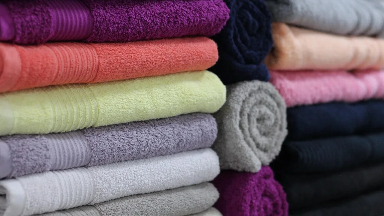 Stack of colorful microfiber towels on bathroom counter with natural light