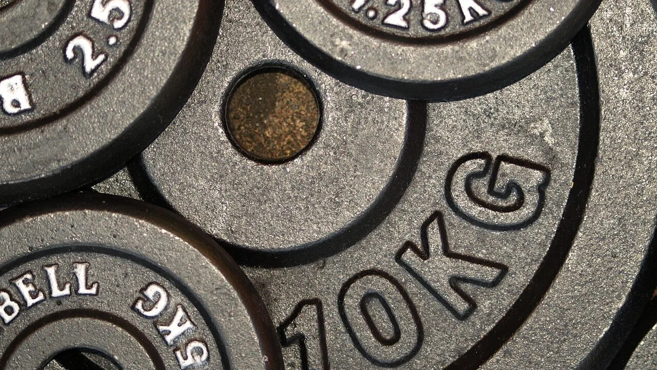 Stack of colorful weight plates on gym floor in natural light