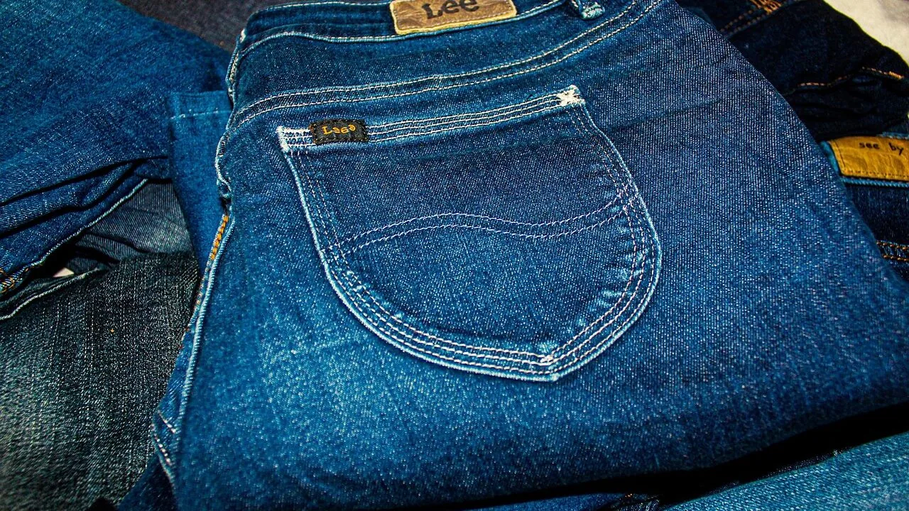 Stack of folded women's jeans in various colors and styles
