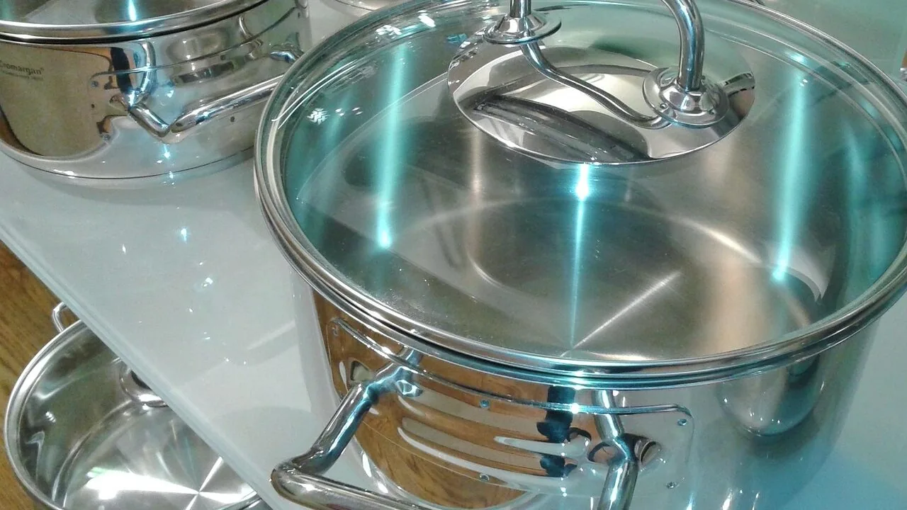 Stainless steel cookware set with pots and pans on kitchen counter