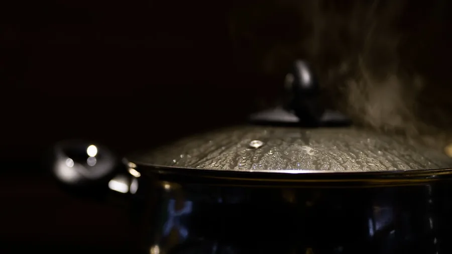 Steam rising from boiling water in kitchen, demonstrating heat and safety awareness during cooking