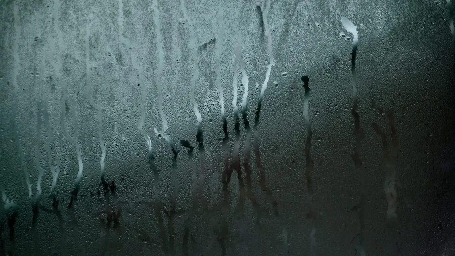 Steamy bathroom mirror with water droplets from shower steam and humidity