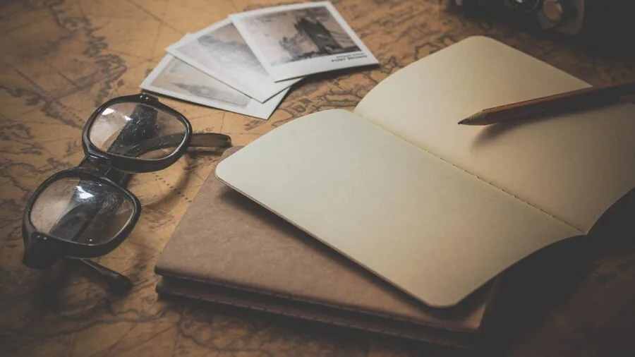 Student organizing academic planner and calendar on wooden desk with notebook and pen