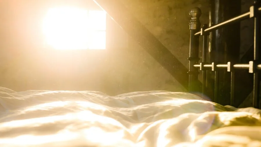 Sunlight filtering through bedroom curtains creating warm, insulated atmosphere in modern home interior