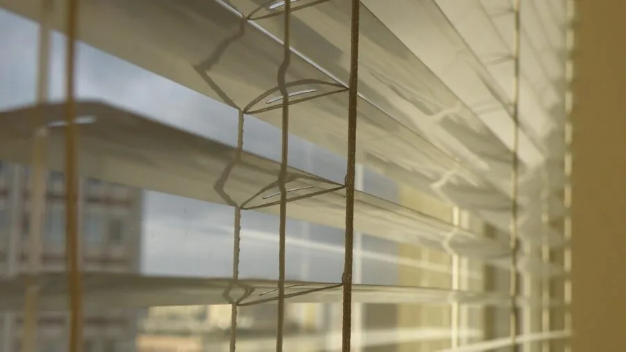 Sunlight streaming through smart blinds in a modern bedroom with automated control