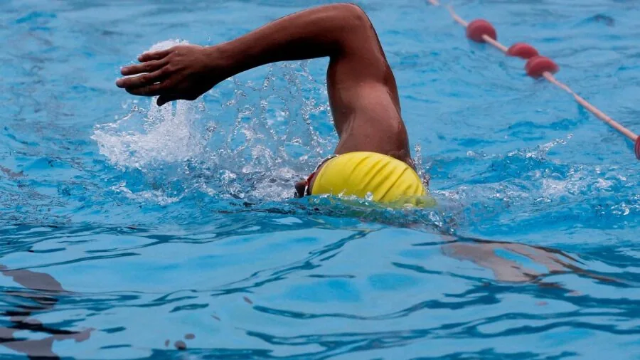 Swimmer enjoying outdoor pool on sunny day with UV protection awareness