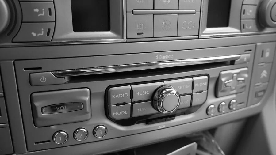 Technician installing car audio equipment inside vehicle dashboard and trunk area