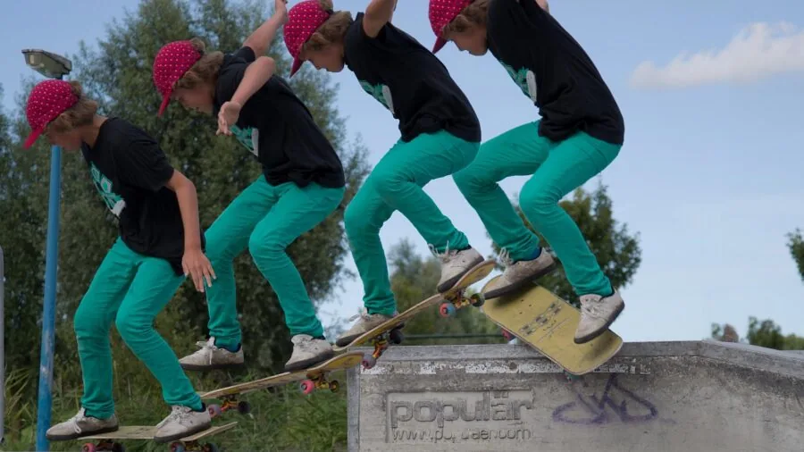Teenage skateboarder practicing tricks on pavement in outdoor skate park setting