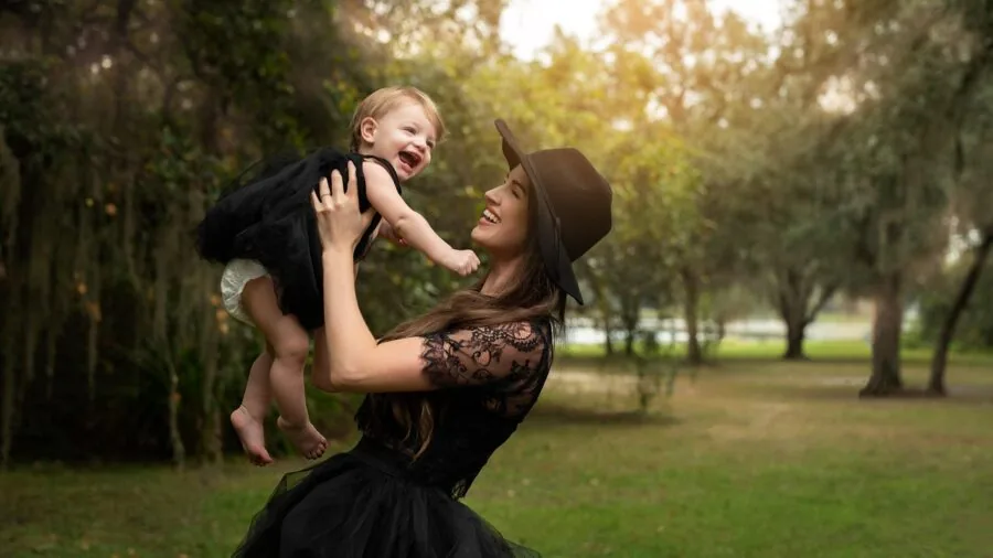 Tired parent changing fussy infant's clothing during nighttime hours