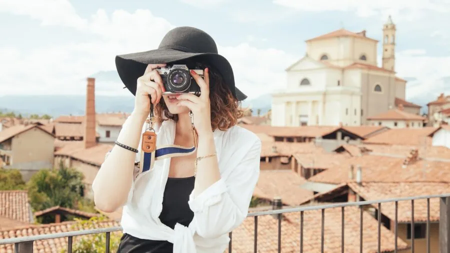 Travel photographer organizing compact gear into camera bag for outdoor adventure