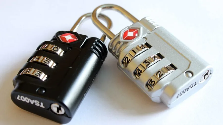 Traveler securing luggage with combination lock at airport terminal before flight