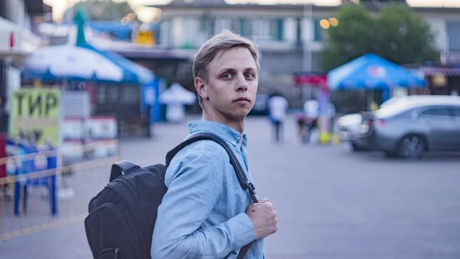 Traveler with bird carrier backpack walking through airport terminal or outdoor journey