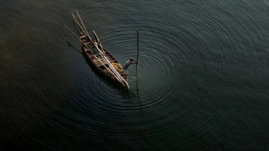 Two people paddling together in a tandem kayak on peaceful flat water surrounded by natural scenery