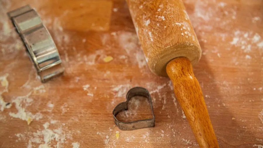Variety of colorful cookie cutters arranged on a wooden surface in a home kitchen setting