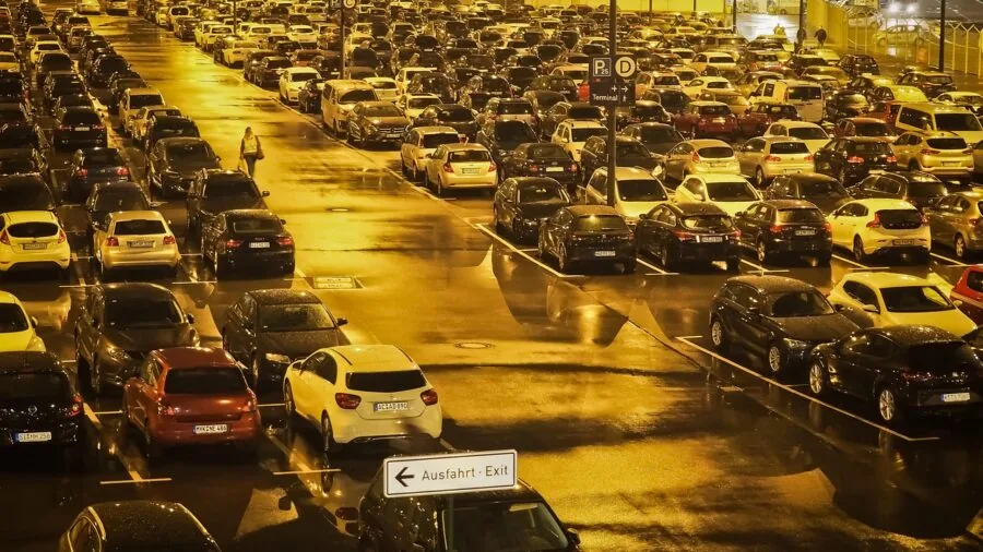 Vehicle backing up in dimly lit parking area with clear visibility from bright white headlights