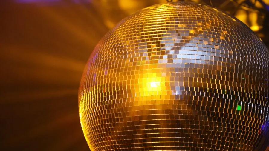 Vibrant disco ball reflecting colorful light beams at an evening dance party celebration