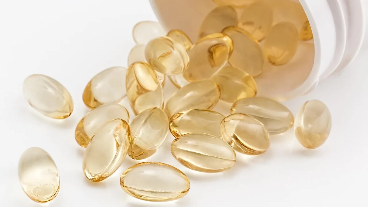 Vitamin D supplement capsules and bottles displayed on white background with natural light