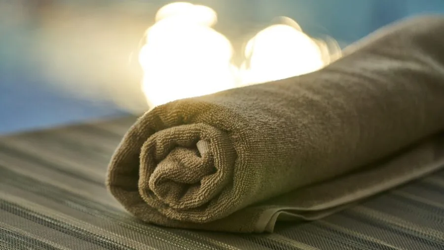 Water droplets on bathroom floor with absorbent towel nearby, showing moisture and drying concepts