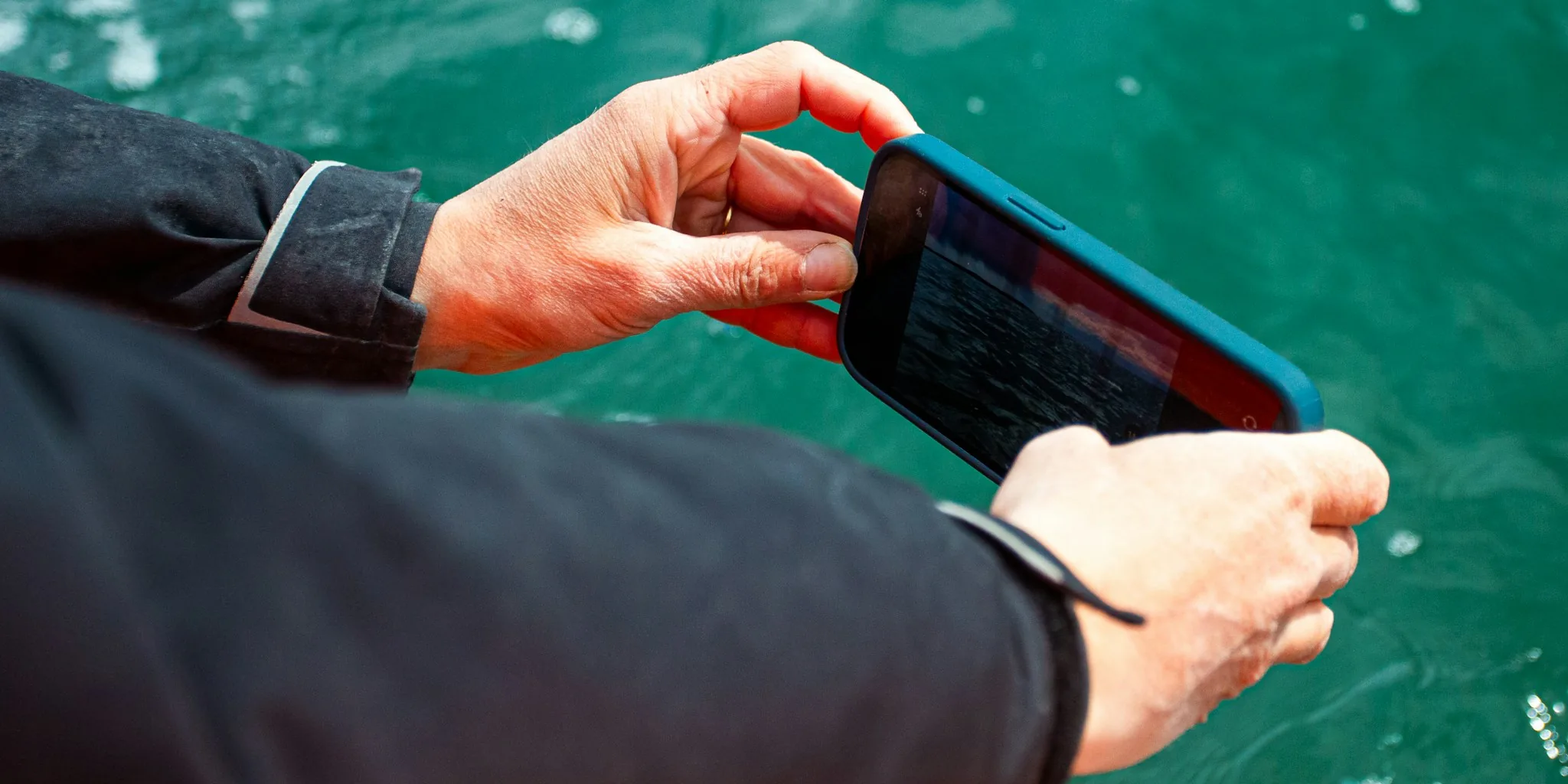 Waterproof Bluetooth speaker displayed near water with natural outdoor lighting