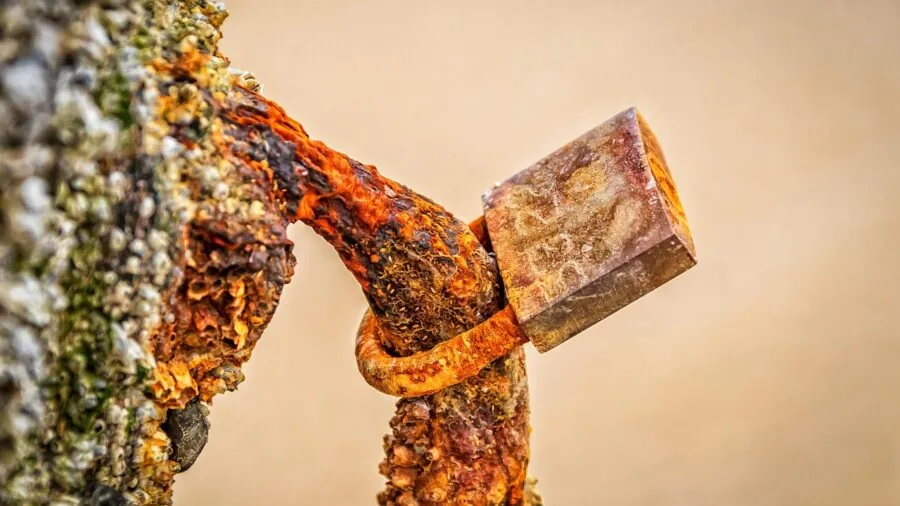 Weathered fishing equipment showing rust and corrosion from saltwater exposure on a boat dock