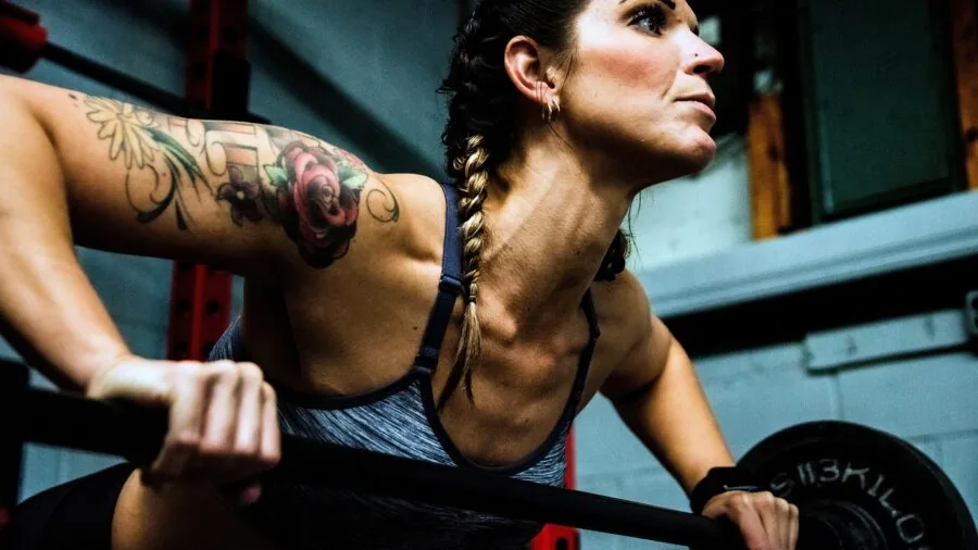 Woman adjusting secure wrist weight attachment while exercising outdoors