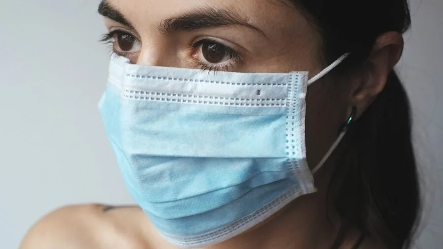 Woman applying face mask to skin during skincare routine at home