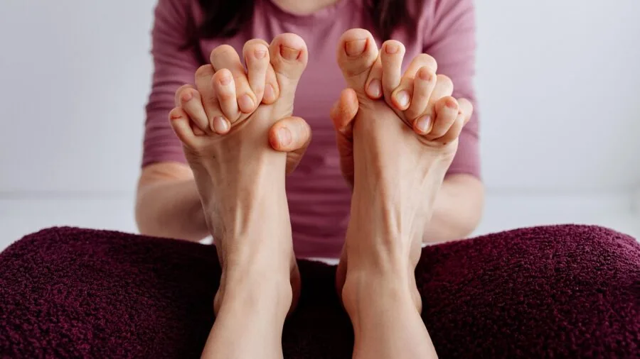 Woman applying foot treatment gel at home during evening routine for foot care and relaxation