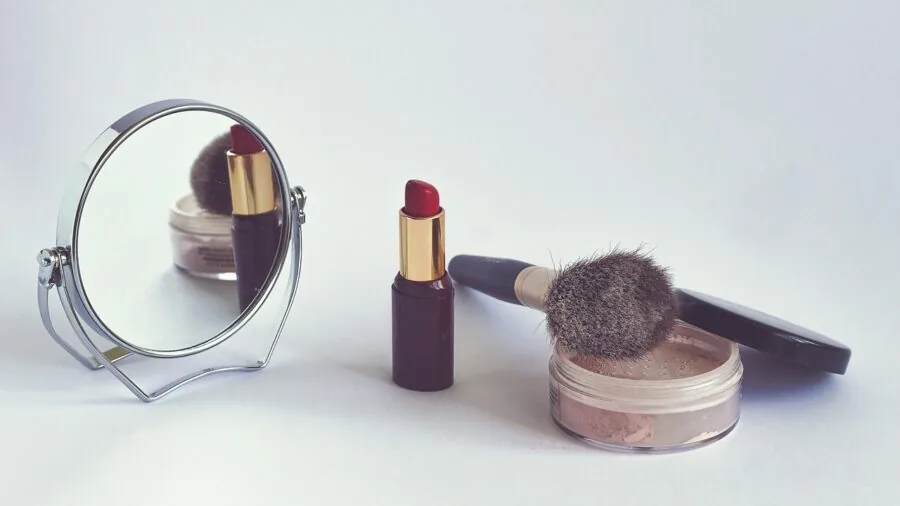 Woman applying liquid lipstick in mirror, focusing on comfort and natural application technique