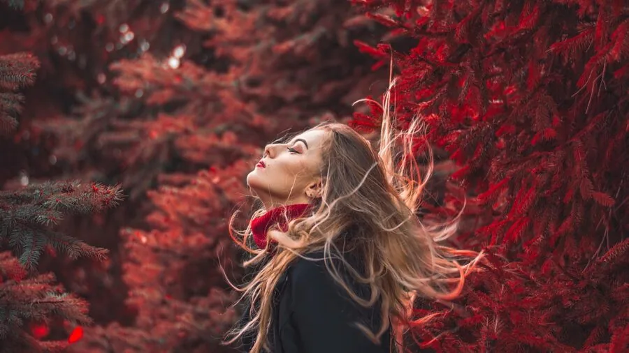 Woman applying texturizing spray to her hair for volume and texture