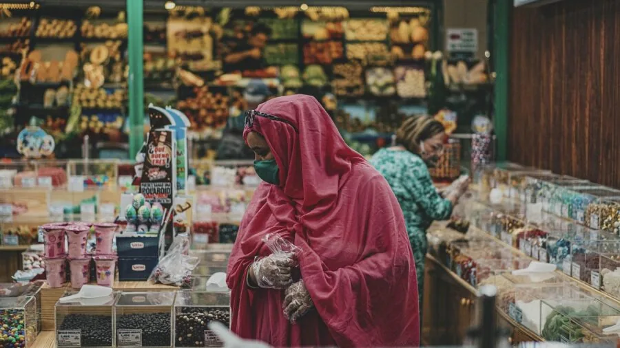 Woman browsing fragrance products on shelves in a modern beauty store