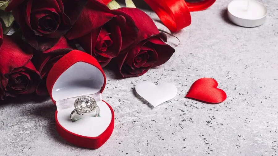 Woman examining her engagement ring in natural light, focusing on the center stone detail