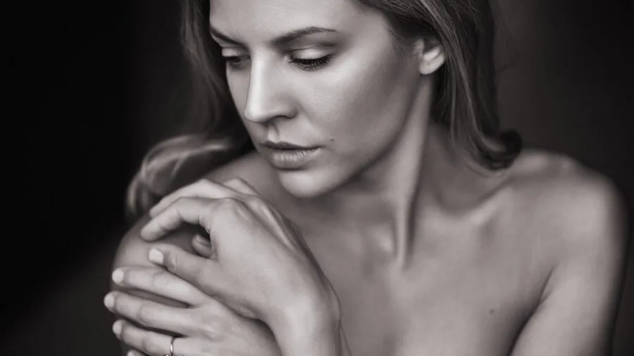 Woman examining her skin tone in natural light to find matching makeup foundation shade