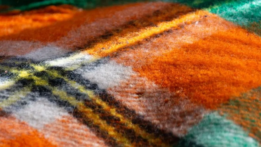 Woman examining soft fabric material quality and texture with hands
